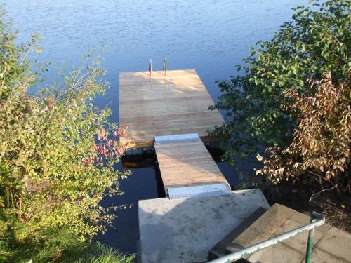 schwimmender Badesteg und Zugangsbrücke belegt mit Holz